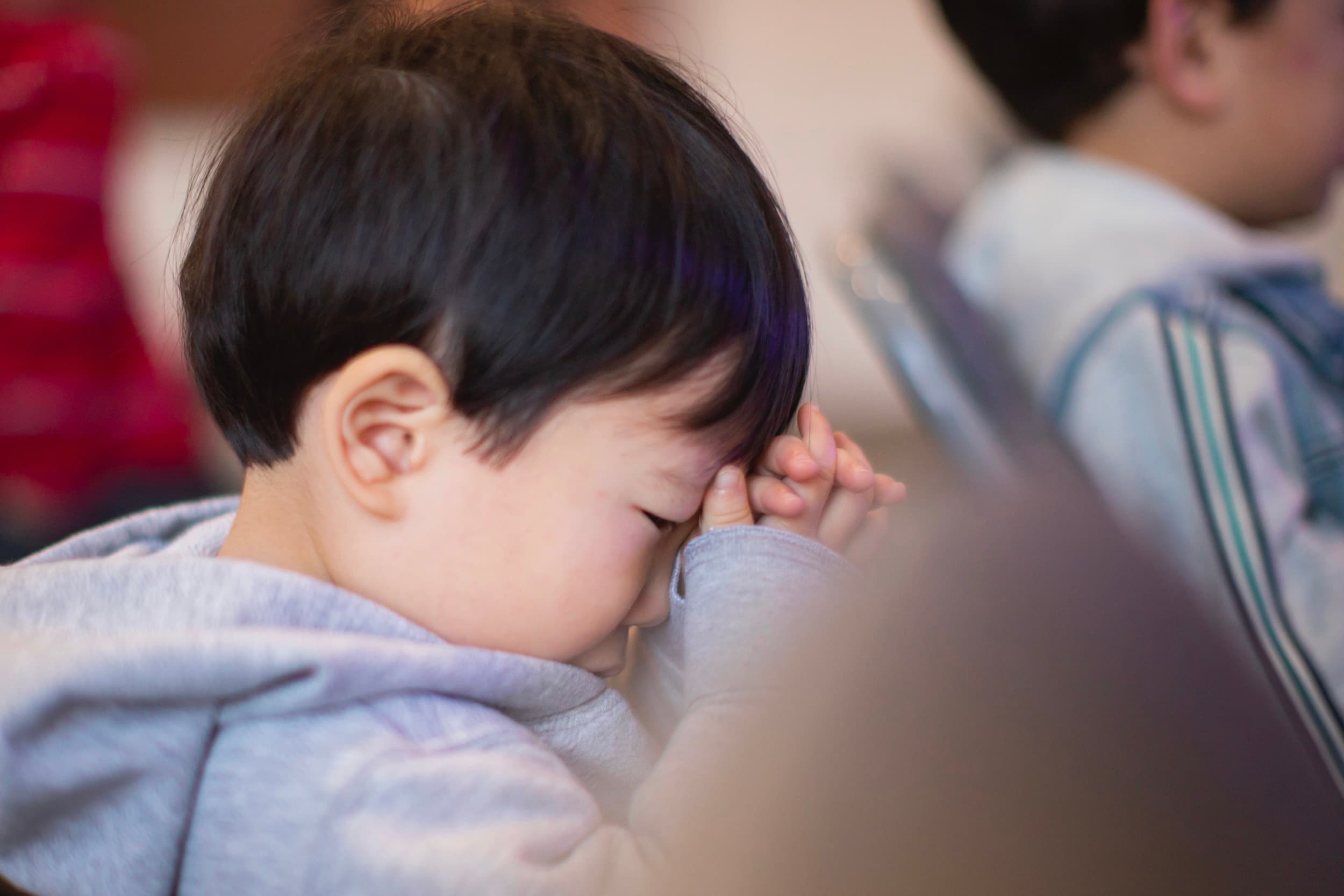 A young child with hands folded in prayer during Crossroads